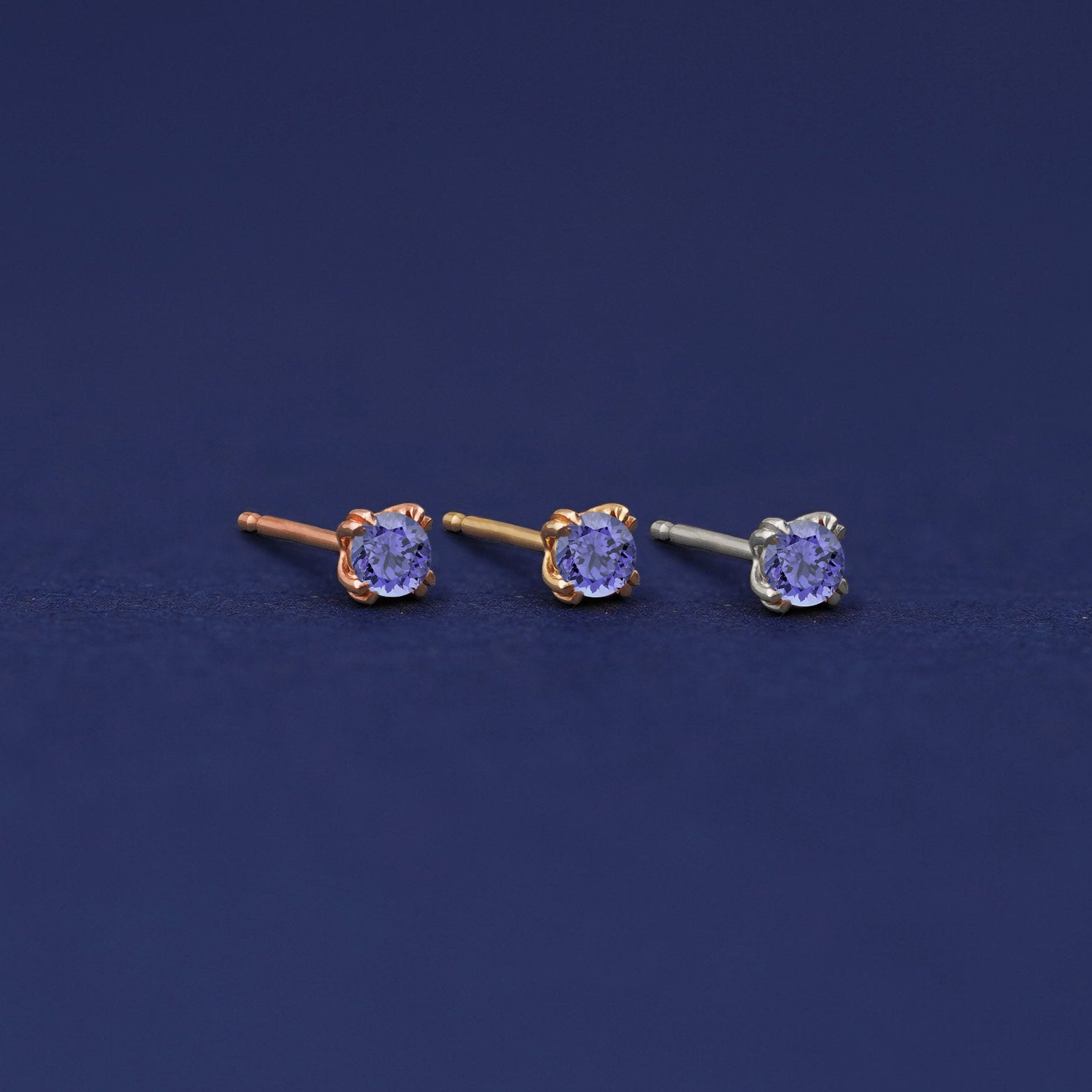 Three versions of the Tanzanite Earring shown in options of rose, yellow, and white gold