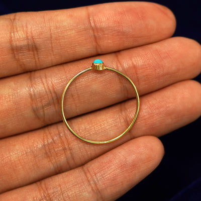 A yellow gold Turquoise Ring in a model's hand showing the thickness of the band