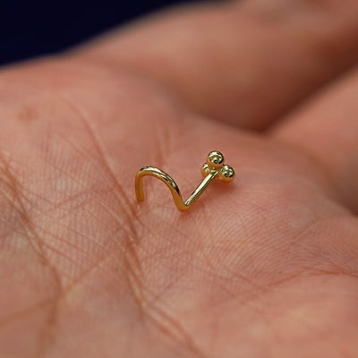 A model's palm holding a Ball Trio Nose Stud to show the details of the screw