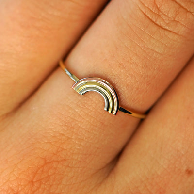 Close up view of a model's fingers wearing a solid gold Rainbow Ring