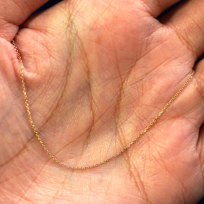 A yellow gold Cable Chain draped on a model's palm