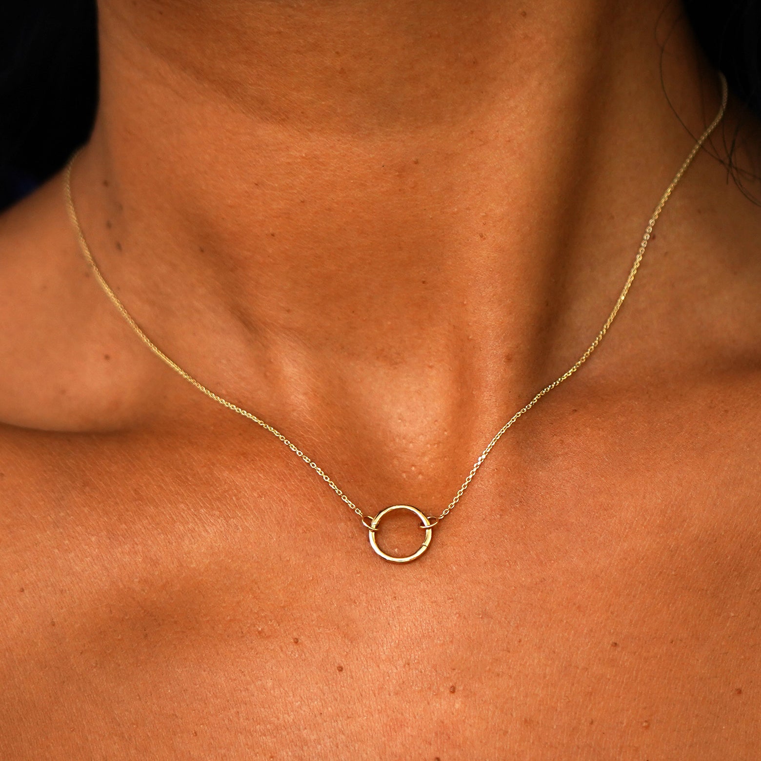 A model's neck wearing a solid 14k yellow gold Lockless Cable Necklace