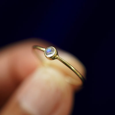 A model holding a Moonstone Ring tilted to show the bezel setting