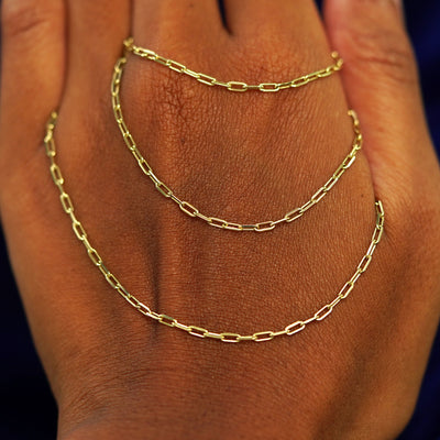 A yellow gold Wrap Necklace wrapped three times around a model's hand