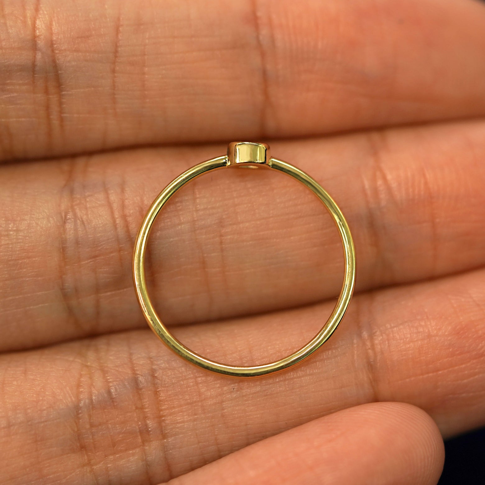 A yellow gold Tanzanite Ring in a model's palm showing the thickness of the band