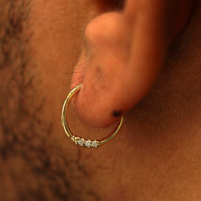 Close up view of a model's ear wearing a 3 Diamond Septum as a hoop earring