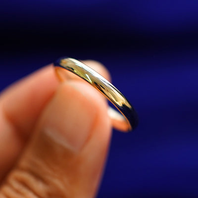 A model holding a Curvy Mirror Band tilted to show the side of the ring