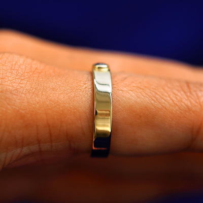 Side view of a sapphire Gemstone Industrial Band on a model's finger
