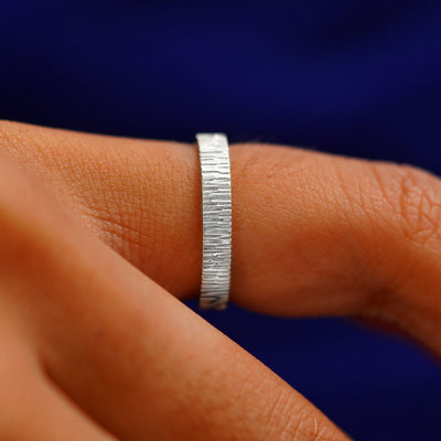 Side view of a Platinum Industrial Wood Band on a model's finger