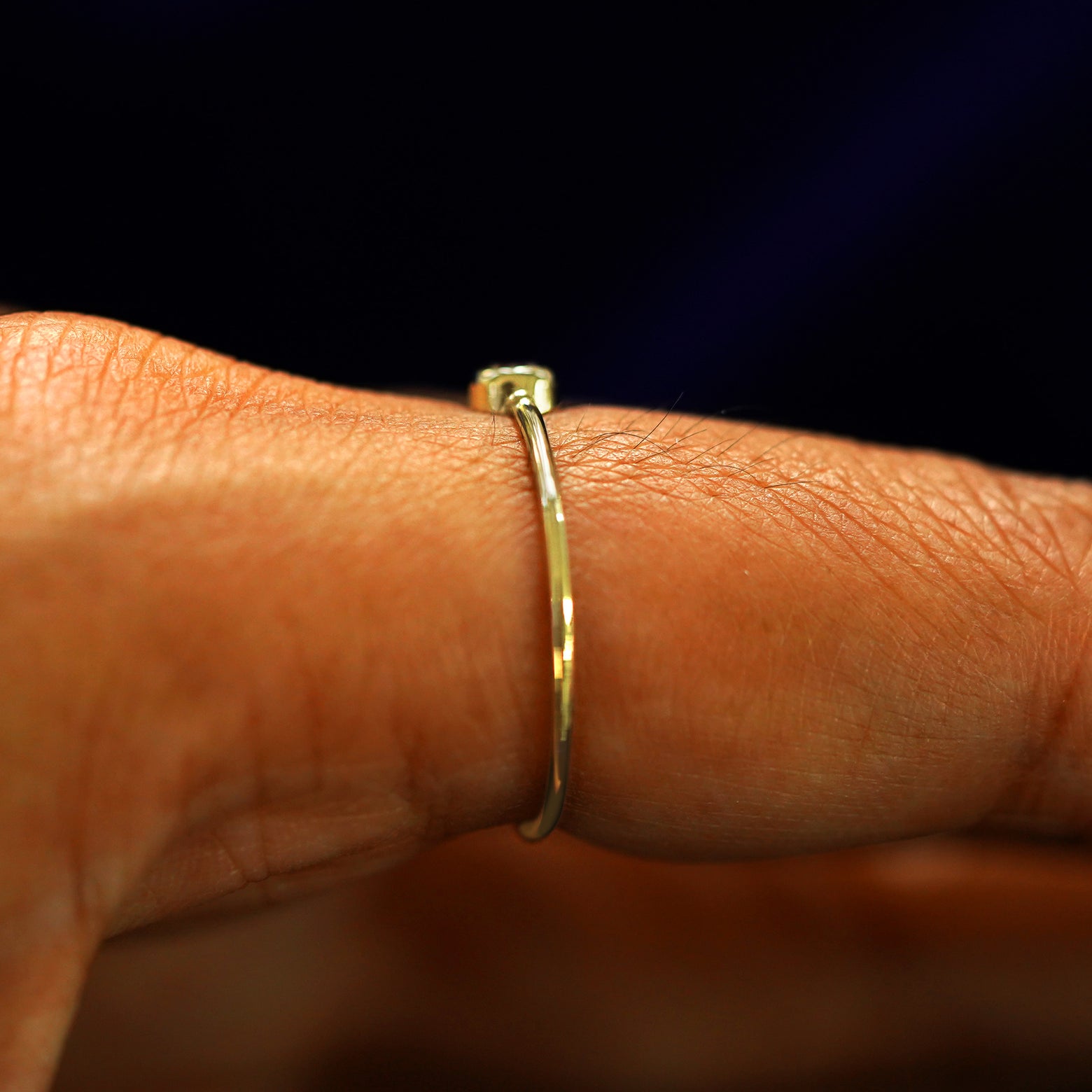 Side view of an Alexandrite Ring on a model's finger