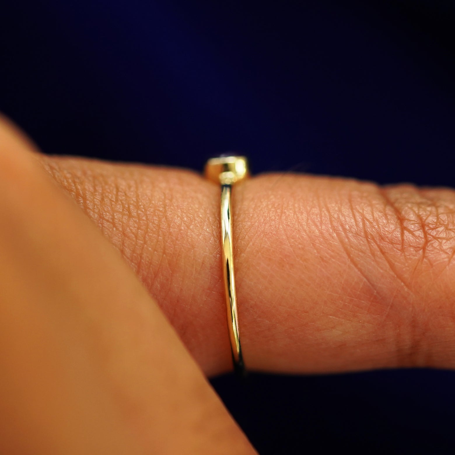 Side view of an Amethyst Ring on a model's finger