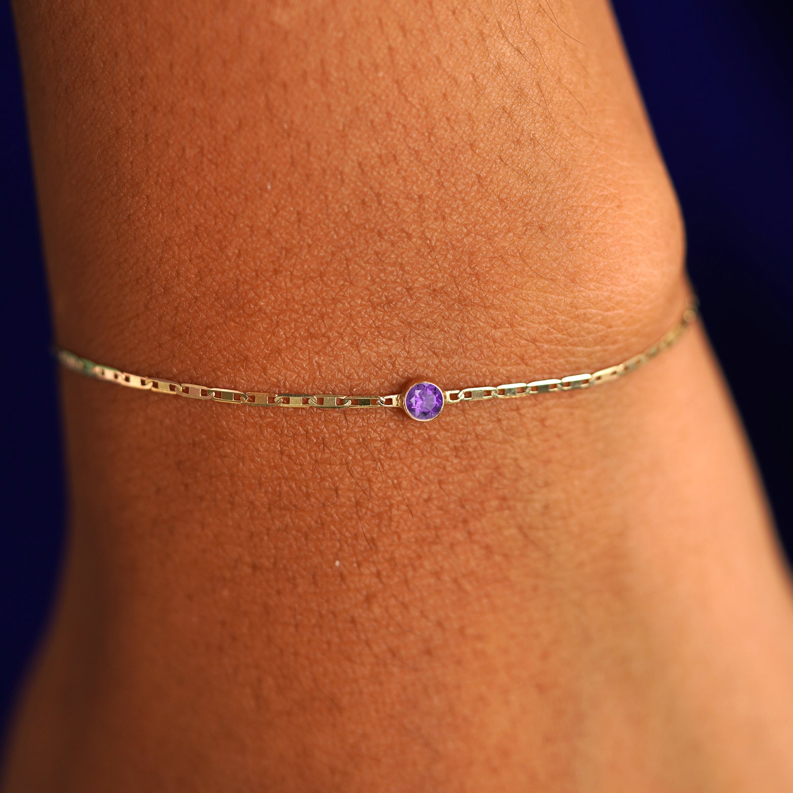 A model's wrist wearing a 14 karat yellow gold Amethyst Bracelet