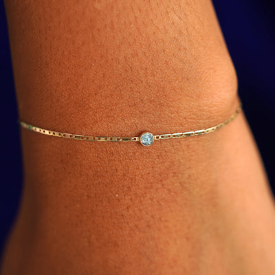 A model's wrist wearing a 14 karat yellow gold Aquamarine Bracelet