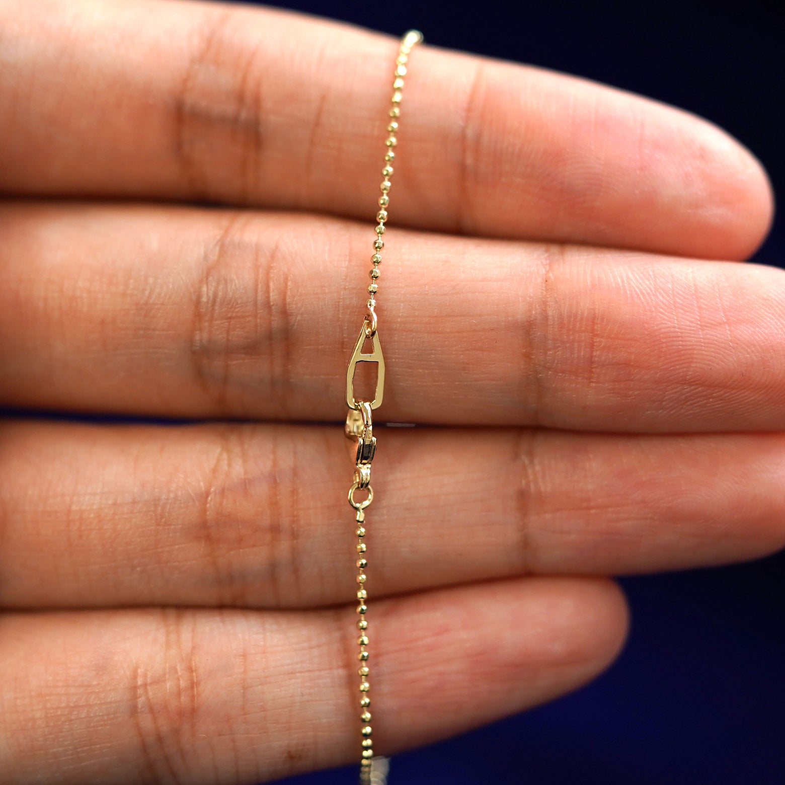 An Automic Gold AU lobster claw clasp on a Bead Chain