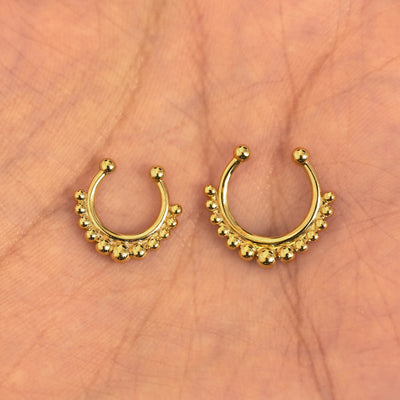 A model's palm holding two versions of the non-pierced Beaded Septum showing the 8mm and 10mm sizes