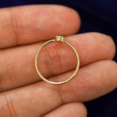 A yellow gold Amethyst Ring in a model's hand showing the thickness of the band