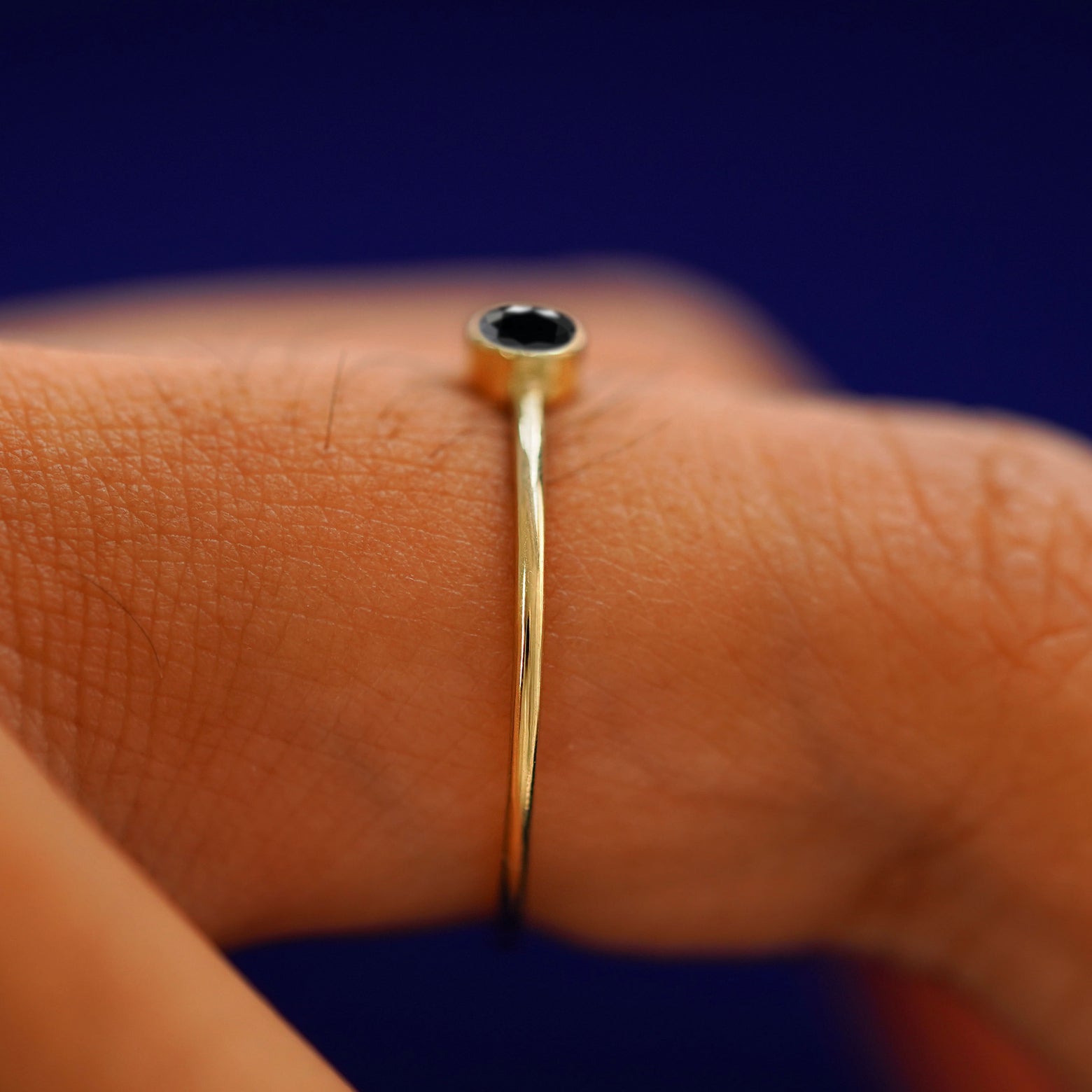Side view of a Black Diamond Ring on a model's finger