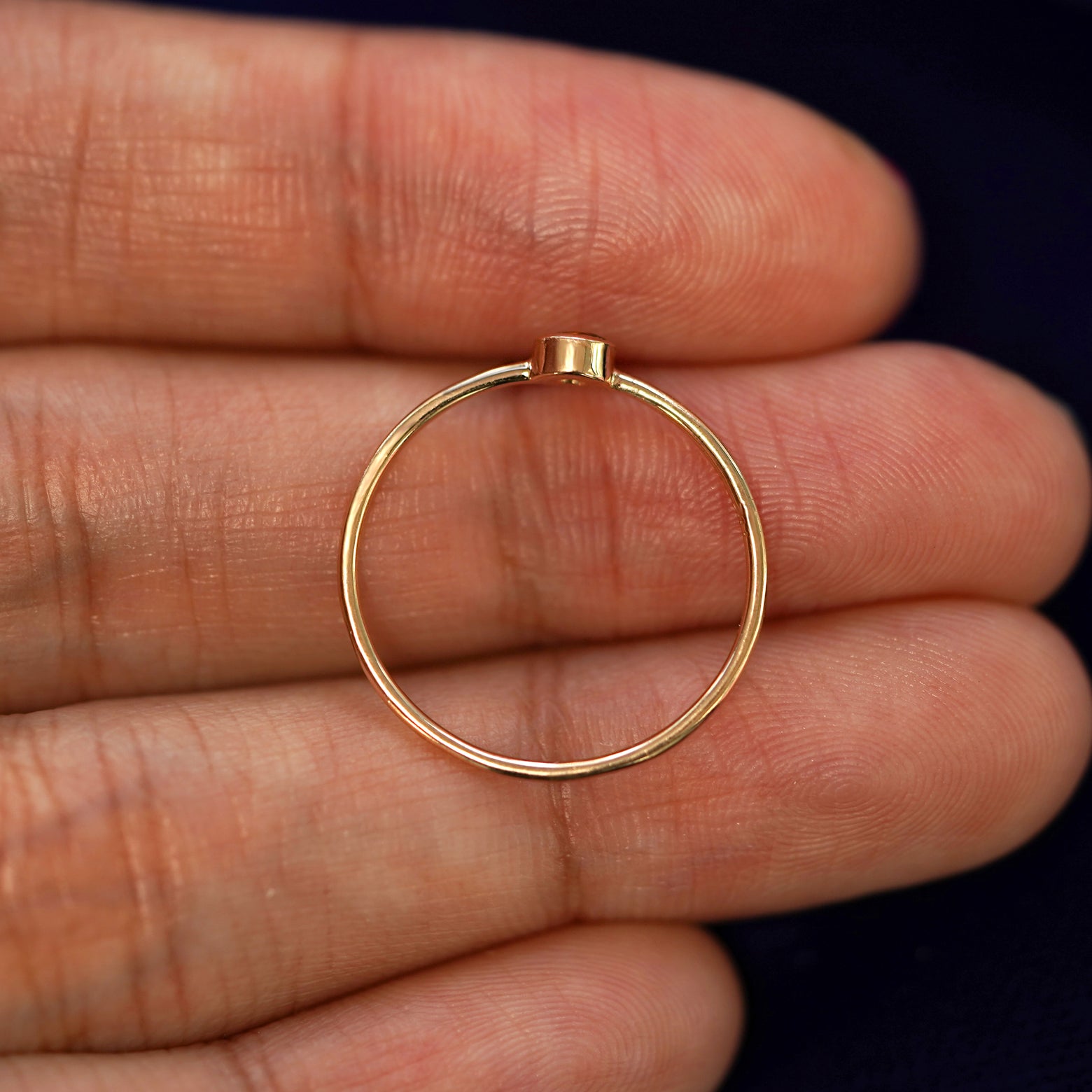 A yellow gold Citrine Ring in a model's hand showing the thickness of the band