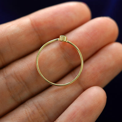 A yellow gold Peridot Ring in a model's hand showing the thickness of the band