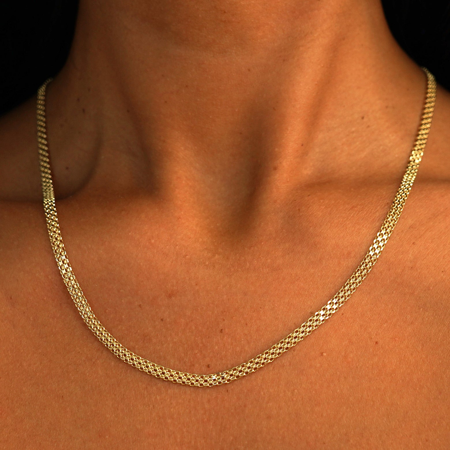 A model's neck wearing a solid 14k yellow gold Bismarck Chain