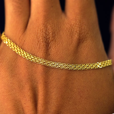 A solid gold Bismarck Chain resting on the back of a model's hand