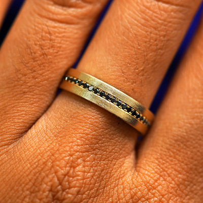 Close up view of a model's fingers wearing a 14k yellow gold Endless Diamond Band
