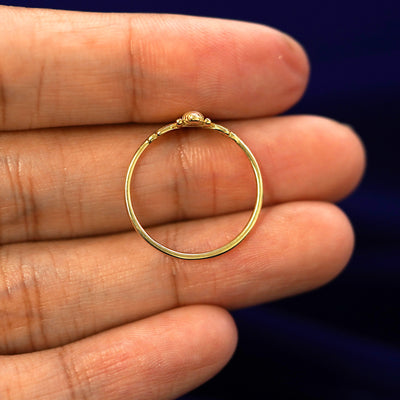 A yellow gold Bee Ring in a model's hand showing the thickness of the band