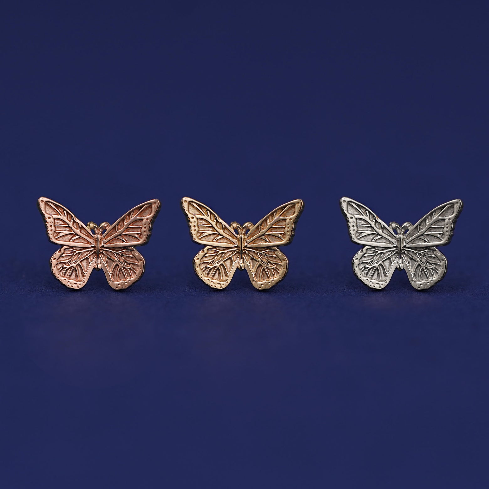 Three versions of the Butterfly Earring shown in options of yellow, white, and rose gold