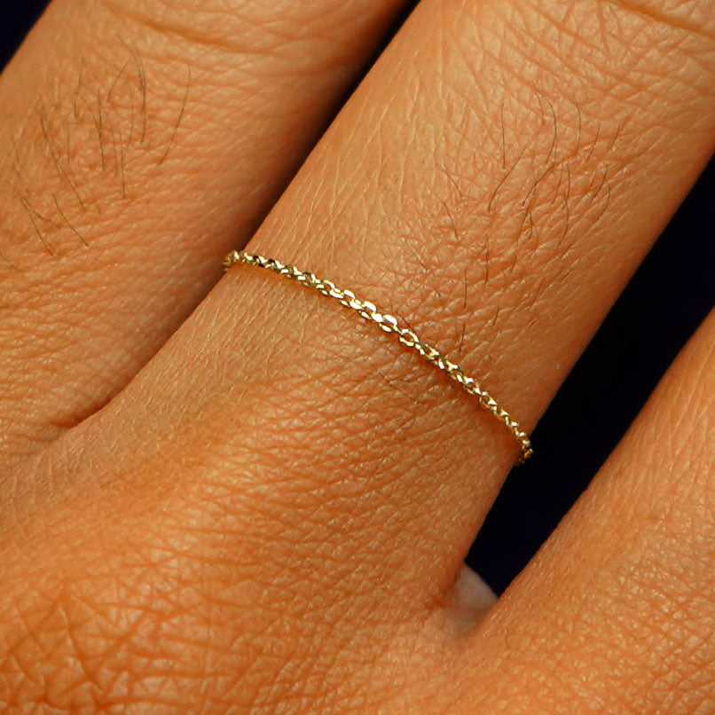 Close up view of a model's fingers wearing a 14k yellow gold Cable Chain Ring