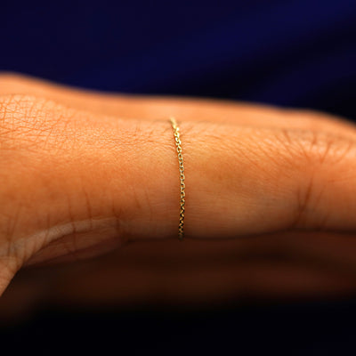 Side view of a solid gold Cable Ring on a model's finger