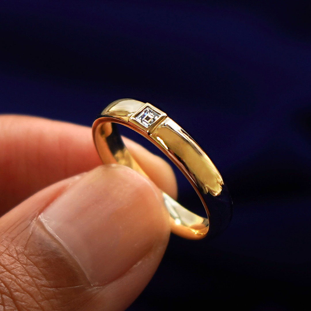 A model holding a Square Carre Cut Diamond Band tilted to show the inside of the ring