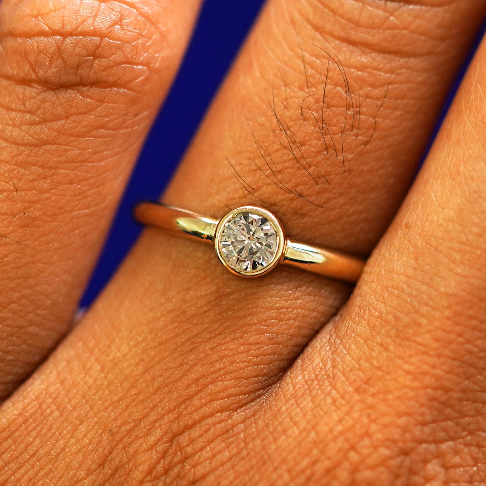 Close up view of a model's fingers wearing a 14k yellow gold 1/3ct Diamond Ring