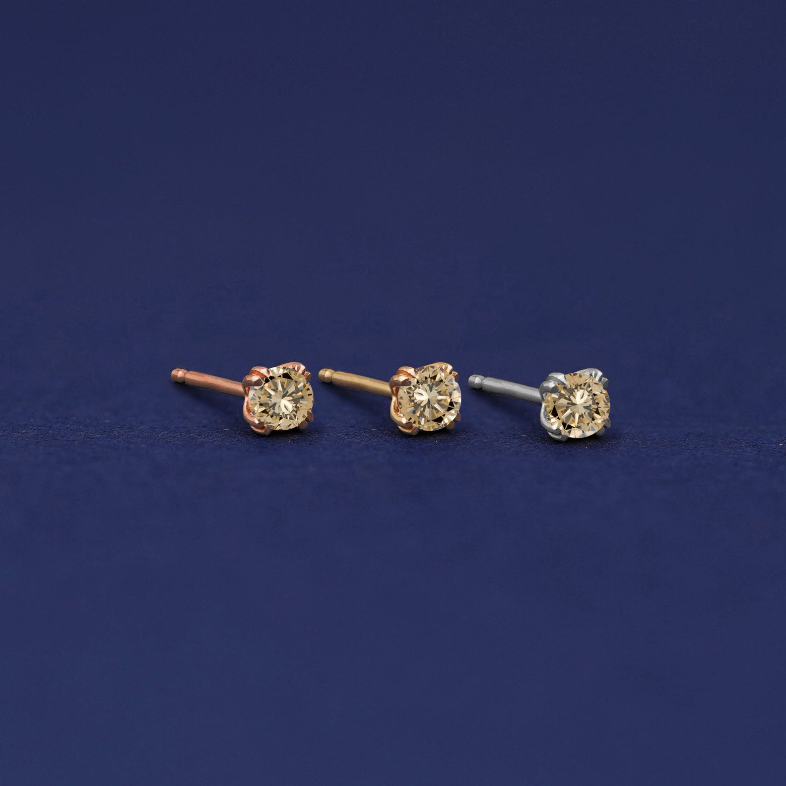 Three versions of the Champagne Diamond Earring shown in options of rose, yellow, and white gold