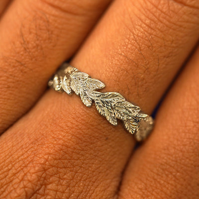 Close up view of a model's fingers wearing a 14k champagne gold Double Leaves Band