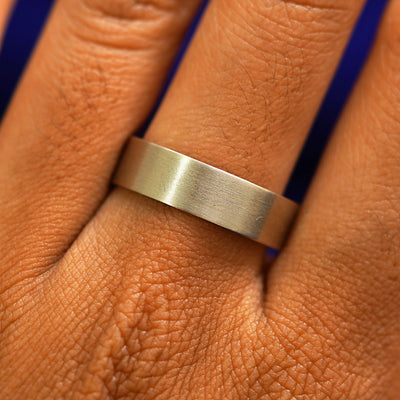 Close up view of a model's fingers wearing a 14k champagne gold Industrial Matte Band