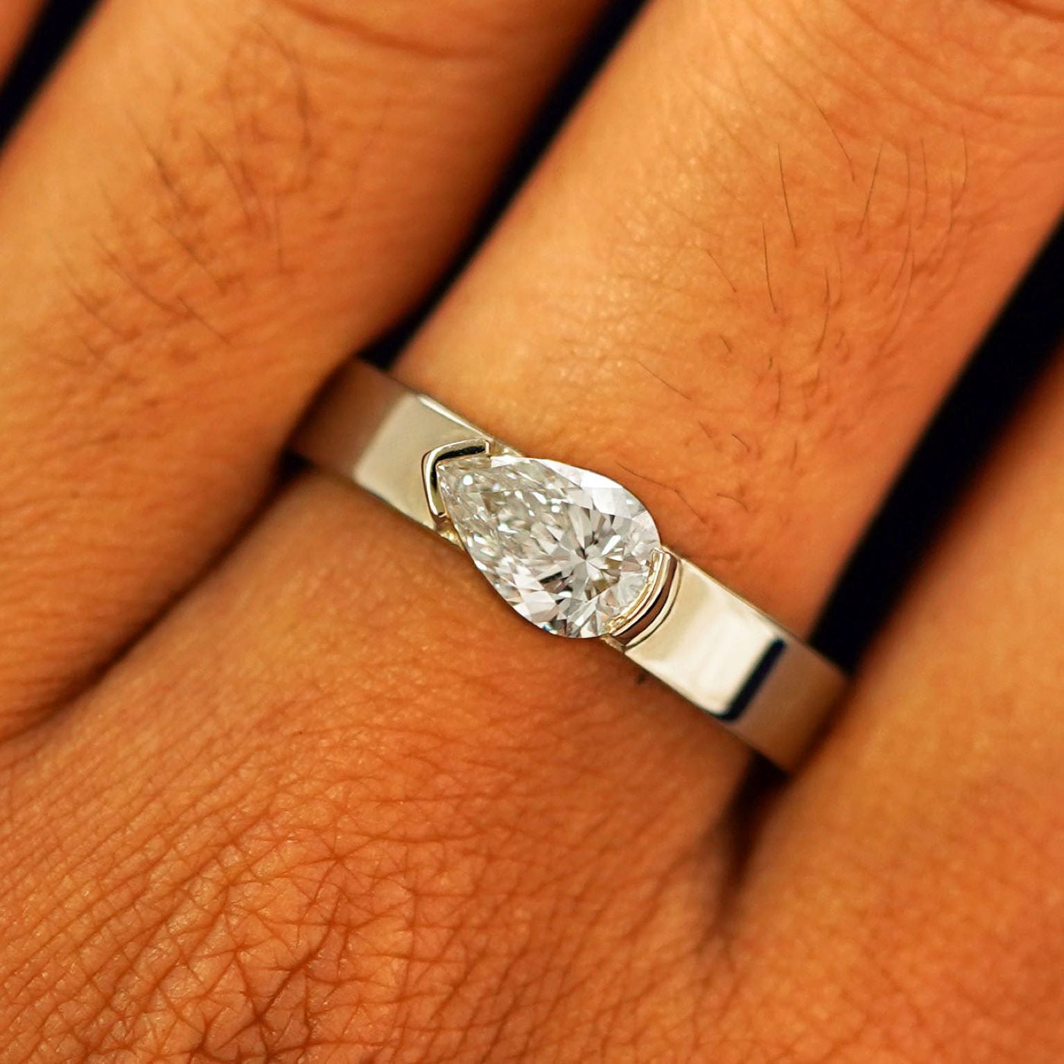 Close up view of a model's fingers wearing a 14k champagne gold Lab Diamond Pear Ring