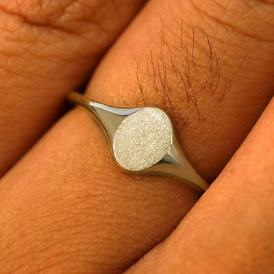 Close up view of a model's fingers wearing a 14k champagne gold Oval Signet Ring