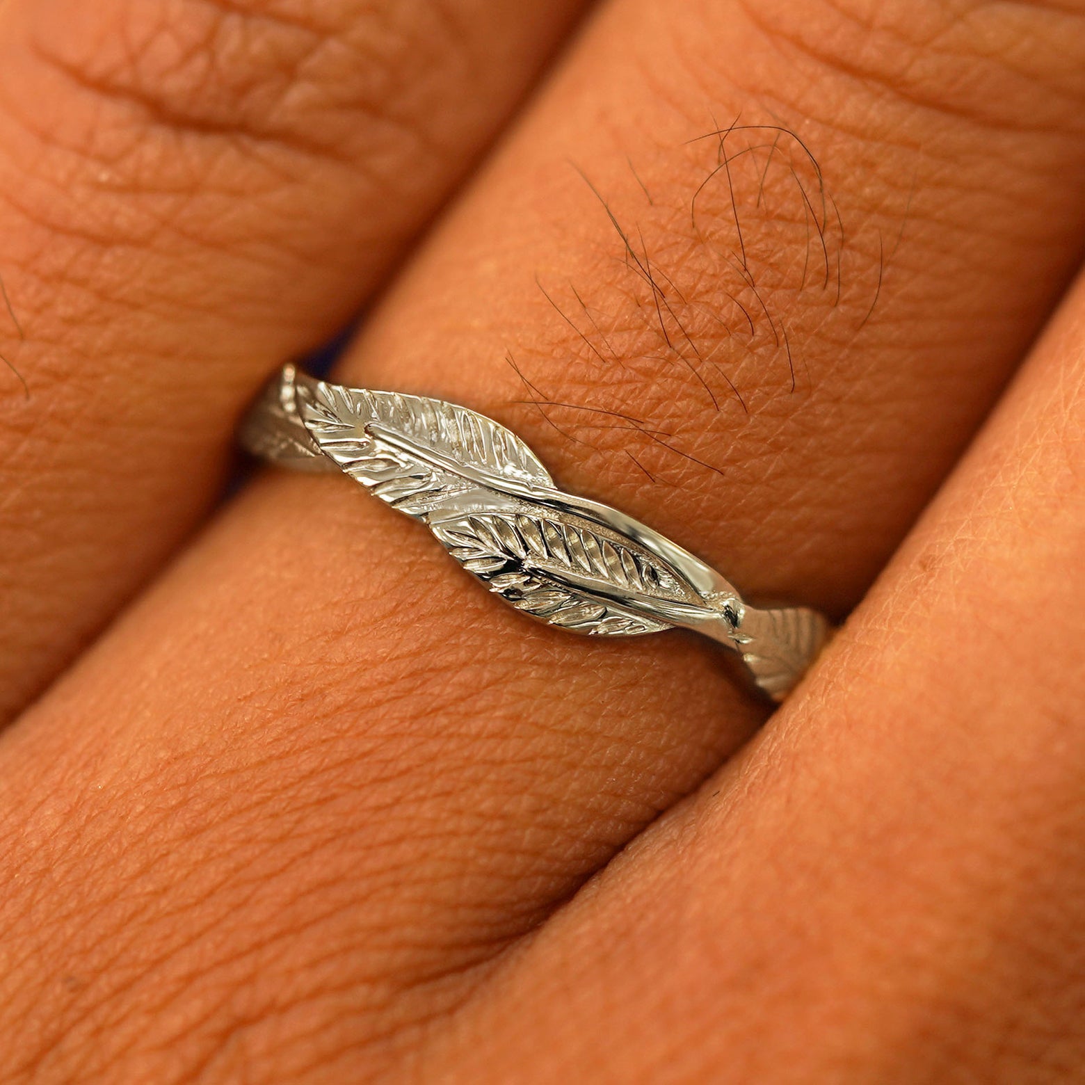 Close up view of a model's fingers wearing a 14k champagne gold Thick Leaves Band