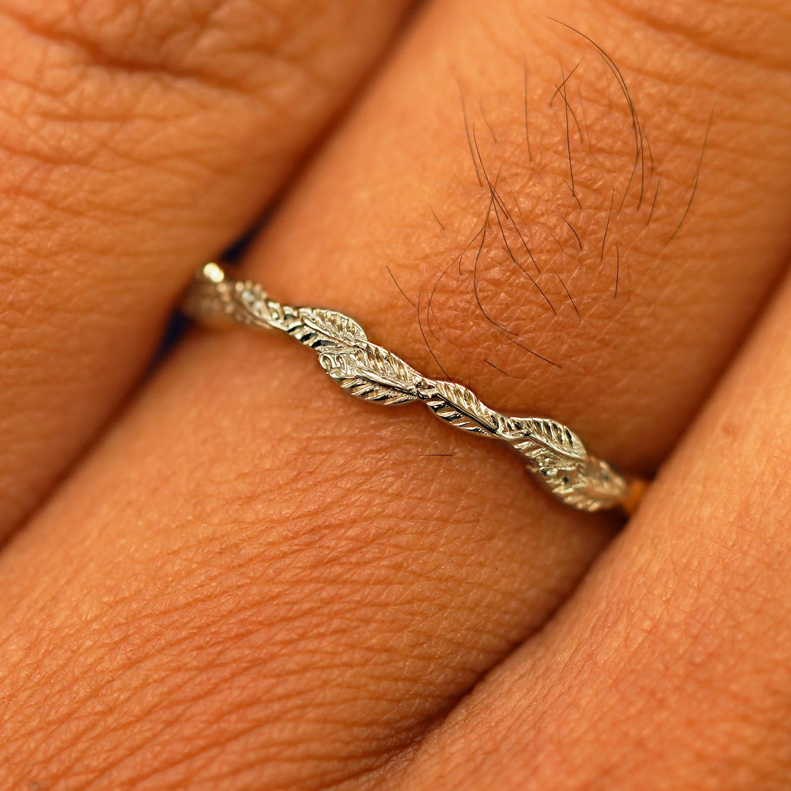 Close up view of a model's fingers wearing a 14k champagne gold Thin Leaves Band