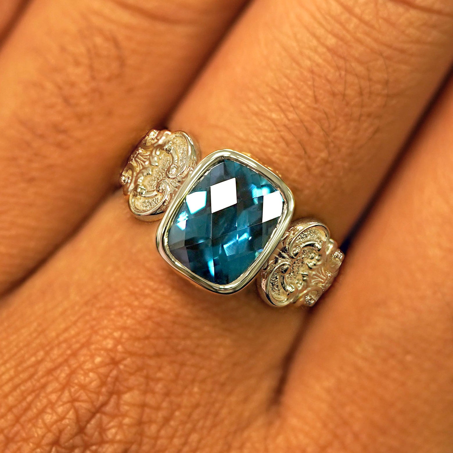 Close up view of a model's fingers wearing a champagne gold London blue topaz Royalty Ring