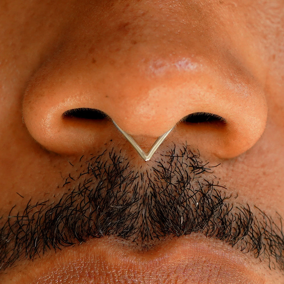 Close up view of a model's face wearing a 14k solid champagne gold Triangle Septum