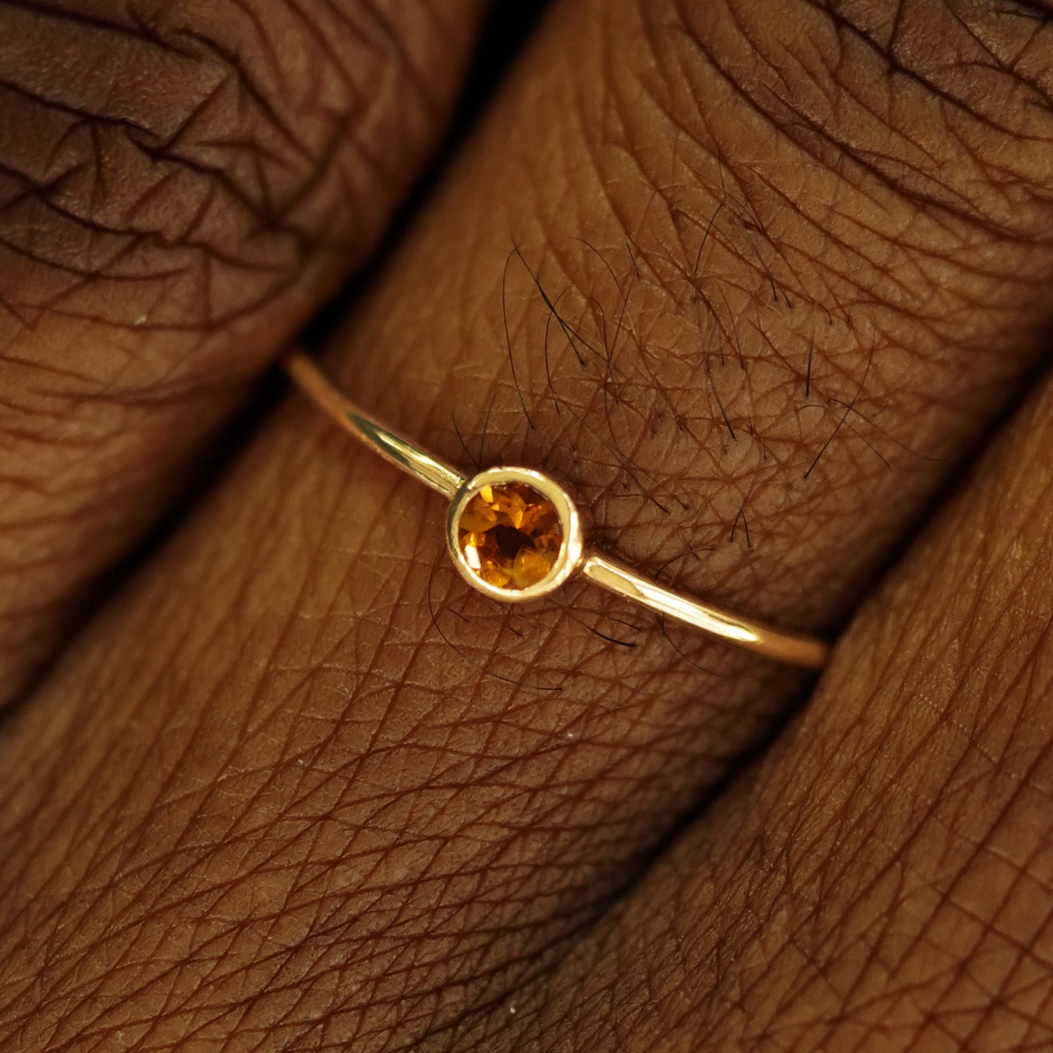 Close up view of a model's fingers wearing a 14k yellow gold Citrine Ring