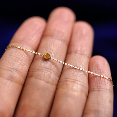 A yellow gold Citrine Bracelet resting on a model's fingers