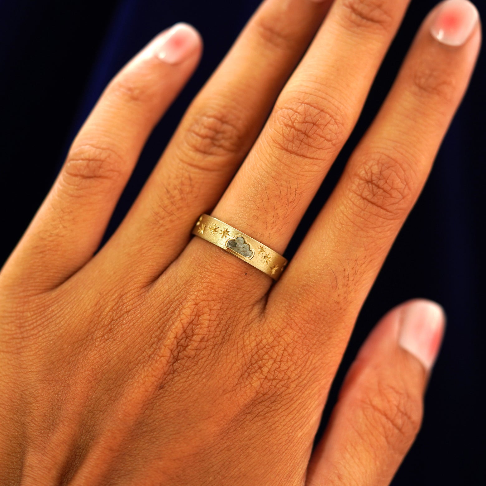 Close up view of a model's hand wearing a yellow gold Cloud Diamond Band