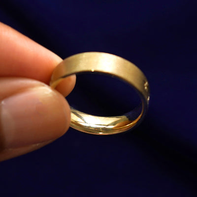 A model holding a Cloud Diamond Band tilted to show the inside of the ring