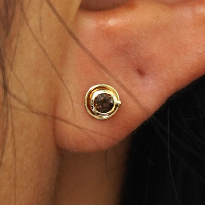 Close up view of a model's ear wearing a yellow gold Coffee Cup Earring
