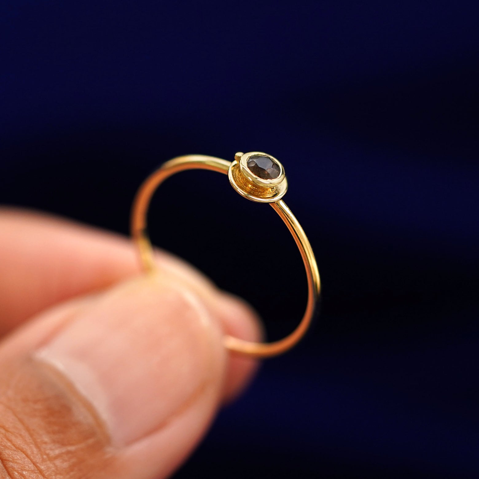 A model holding a Coffee Cup Ring tilted to show the side of the ring