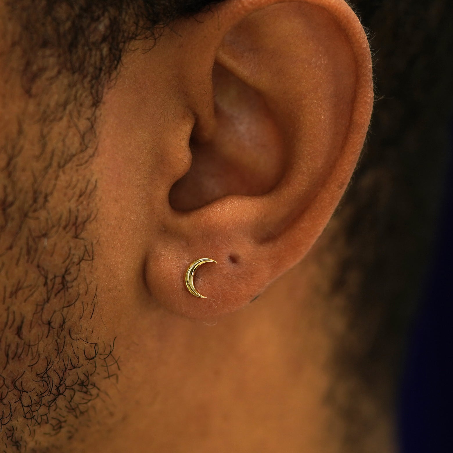 A model's ear wearing a 14k gold Moon Earring