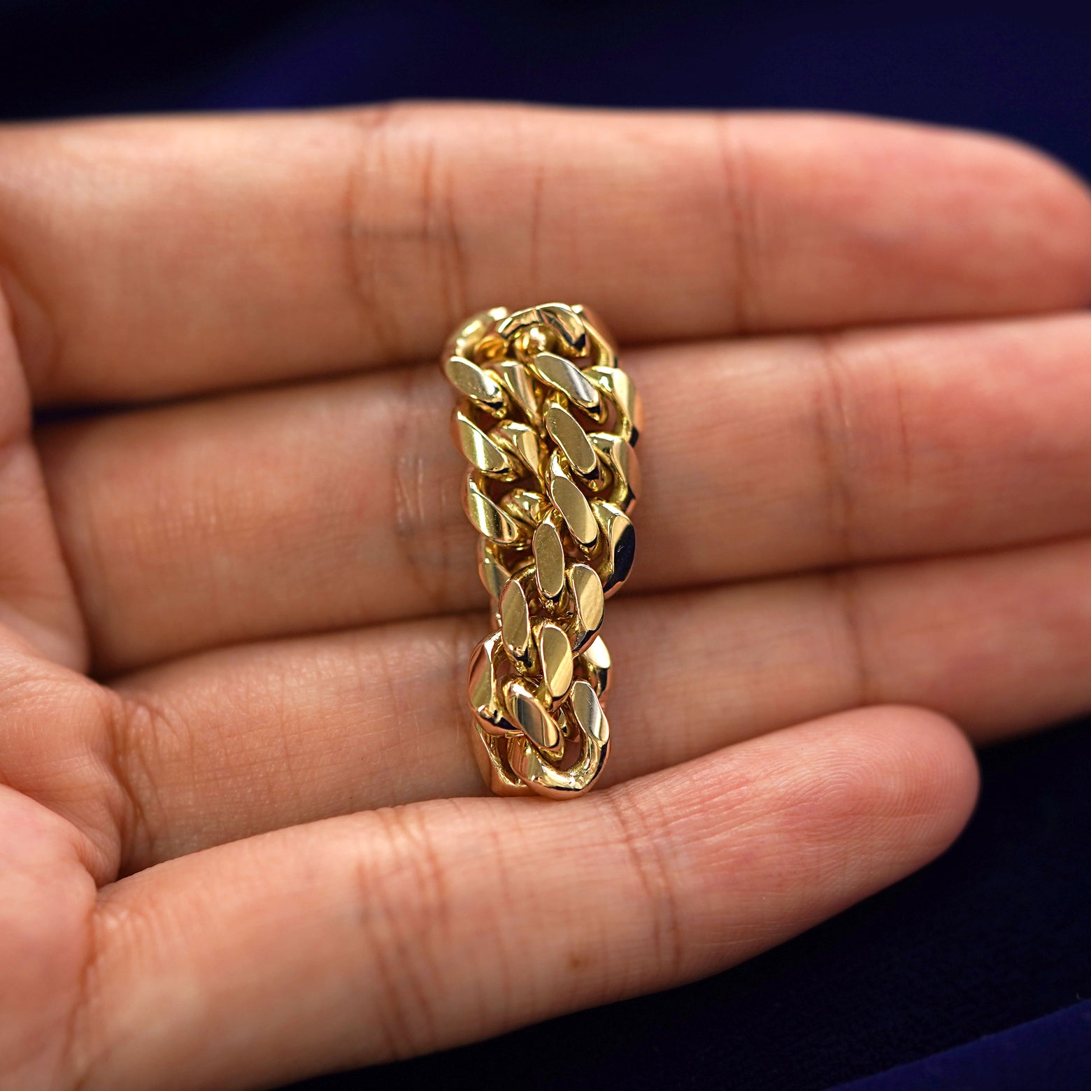 A solid yellow gold Miami Ring twisted a model's finger