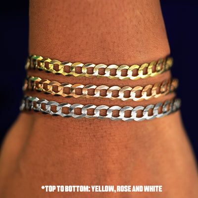 Close up view of a model's wrist wearing three versions of the Curb Bracelet in options of rose, yellow, and white gold